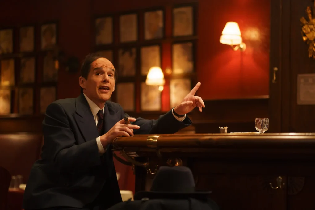 Personaje de Blue Moon (2025) de Richard Linklater hablando solo en un bar, atrapado en un largo monólogo nocturno