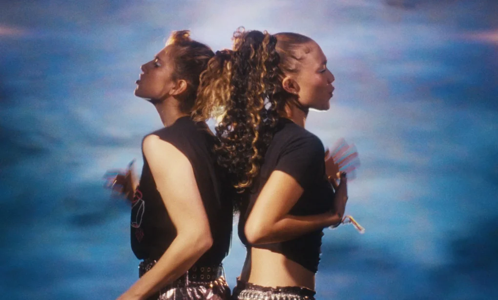Imagen de una escena de Stereo Girls, dos jóvenes bailando frente al mar