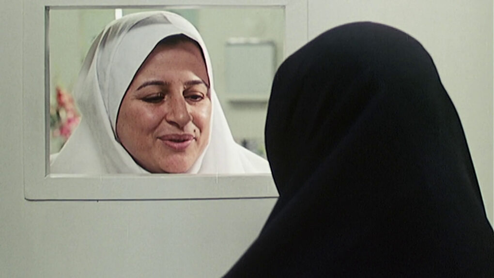 Mujer tras ventanilla en hospital en El círculo (2000) de Jafar Panahi