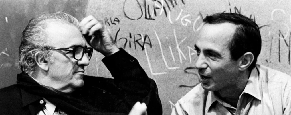 Federico Fellini conversa con Nino Rota en una fotografía en blanco y negro.
