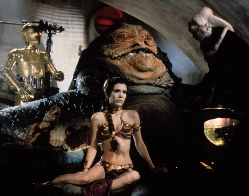 Carrie Fisher interpreta a la princesa Leia en una escena de El retorno del Jedi, junto a Jabba the Hutt.