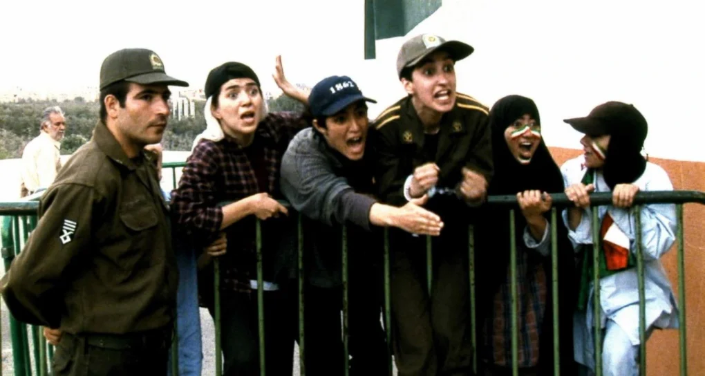 Fotograma de Offside (Fuera de juego) de Jafar Panahi con varias jóvenes retenidas junto a un soldado a las puertas del estadio.