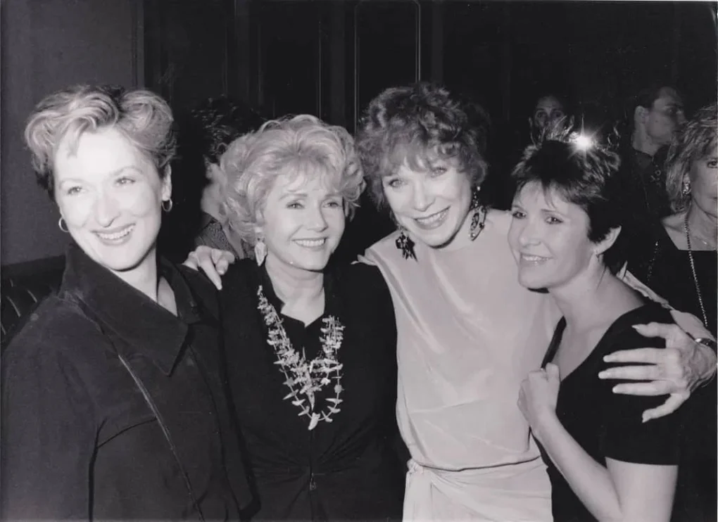 Carrie Fisher, Debbie Reynolds, Shirley MacLaine y Meryl Streep posan juntas en una fotografía promocional relacionada con Postales desde el filo.