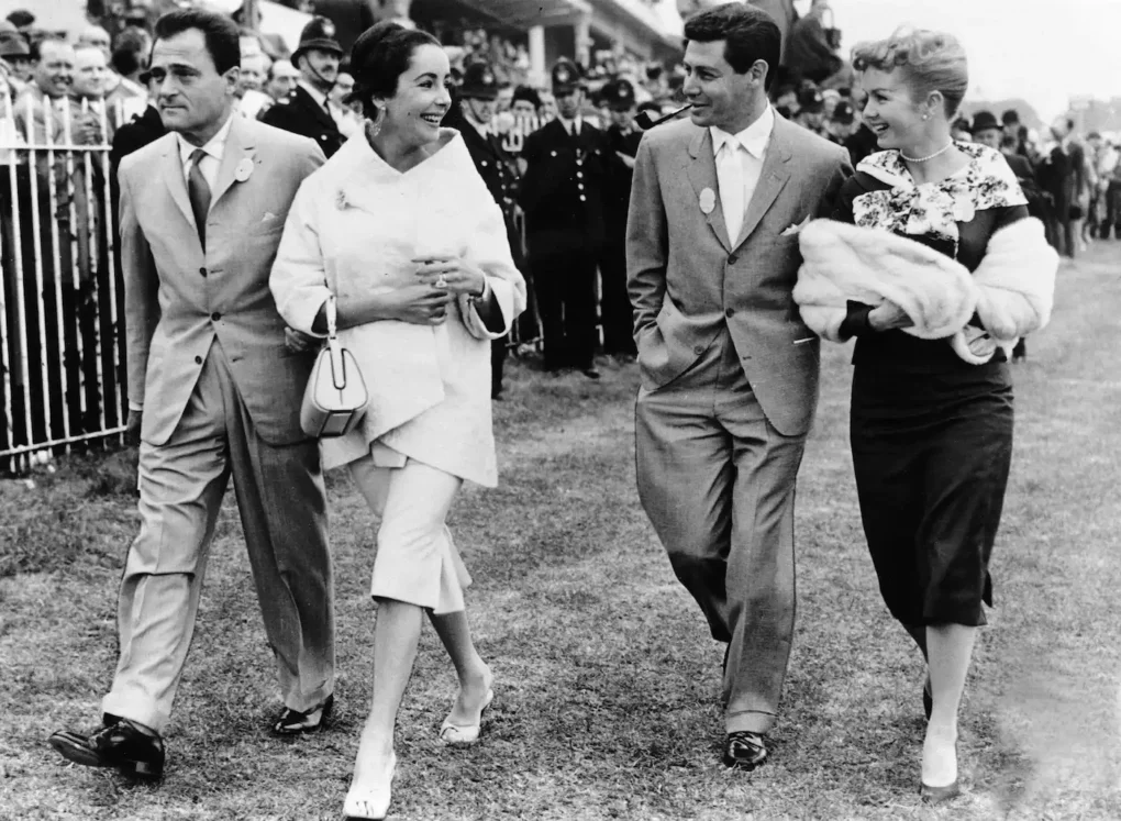 Debbie Reynolds, Eddie Fisher, Elizabeth Taylor y Mike Todd caminan juntos en una fotografía de archivo en blanco y negro.
