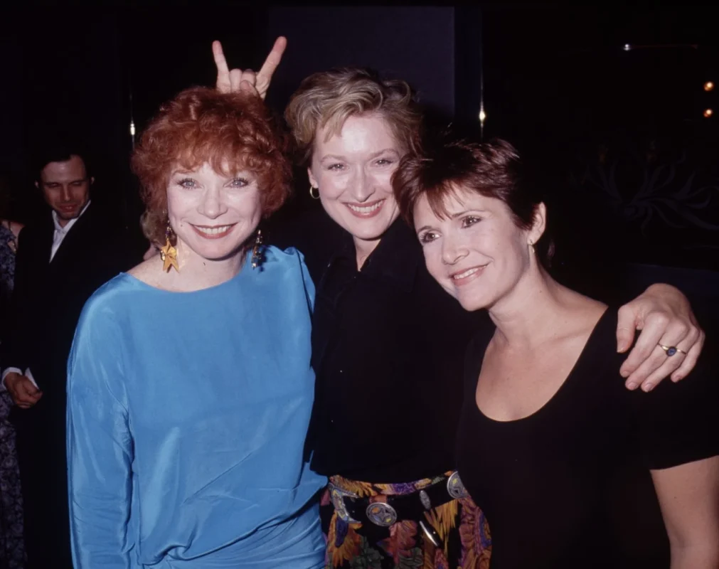 Meryl Streep, Shirley MacLaine y Carrie Fisher posan juntas en una fotografía promocional vinculada a Postales desde el filo.