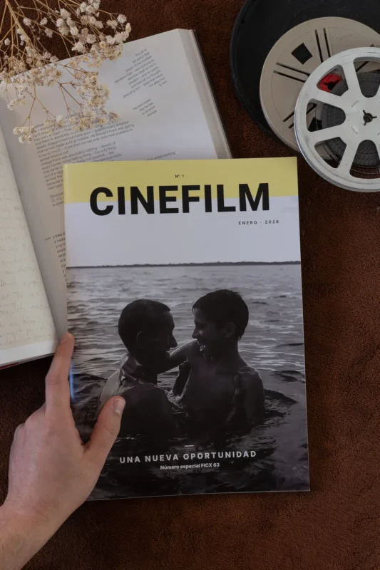 Mano sosteniendo la portada de la revista CineFilm número 1 sobre fondo marrón