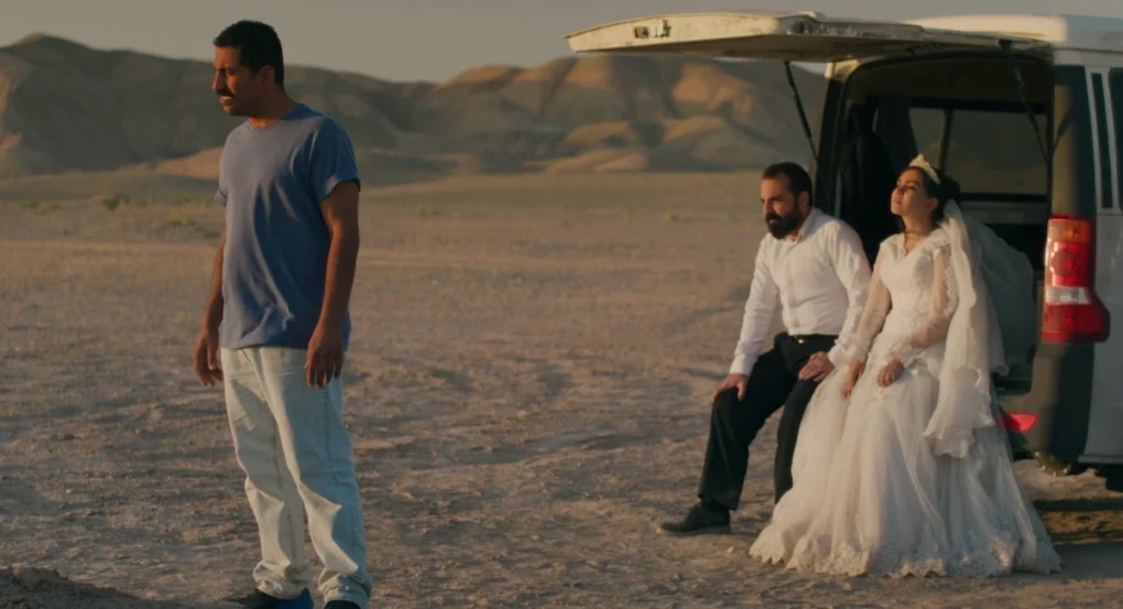 Tres personajes junto a una furgoneta en el desierto al atardecer en Un simple accidente (2025), de Jafar Panahi