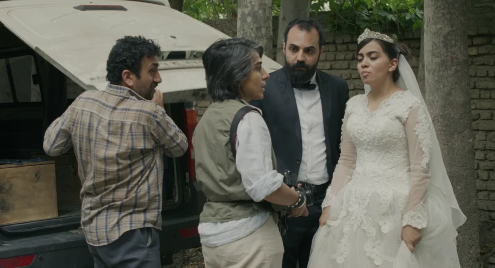 Grupo de personajes junto a una furgoneta, con una novia vestida de blanco, en Un simple accidente (2025), de Jafar Panahi