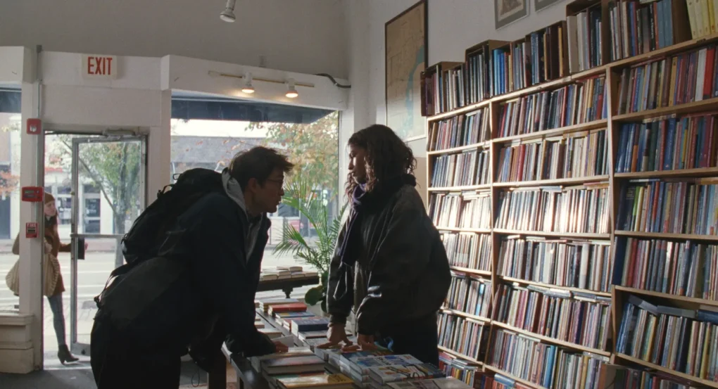 Robert Pattinson y Zendaya conversando en una librería en The Drama (2026)