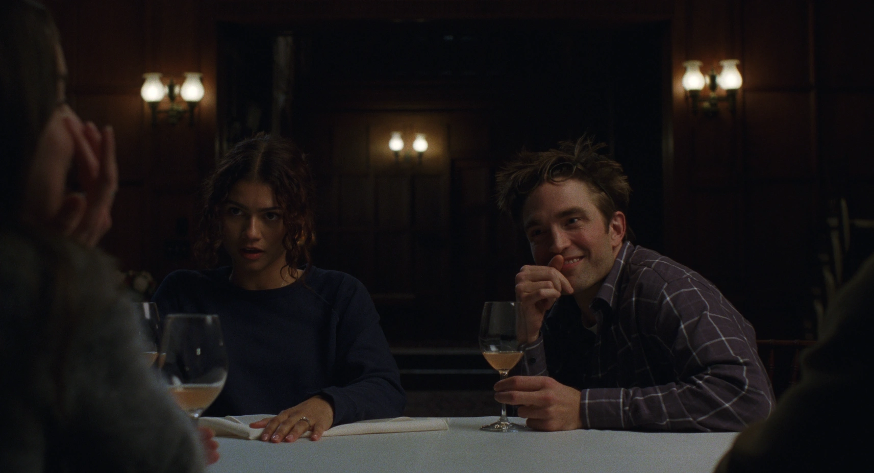 Zendaya y Robert Pattinson durante una cena de confesiones en The Drama (2026)